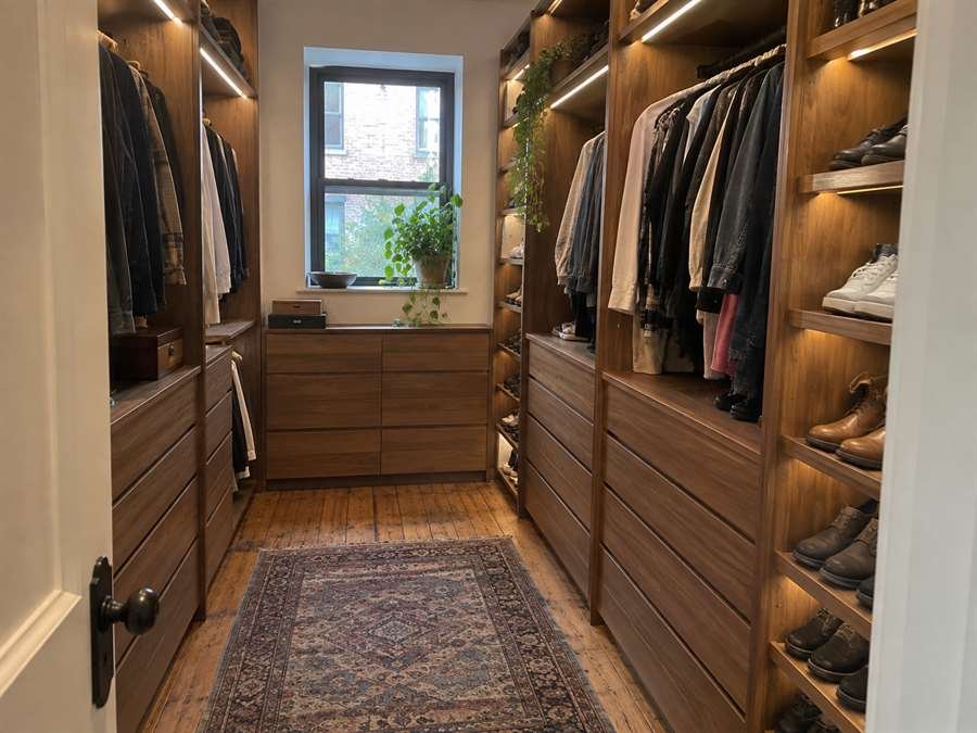 Walnut walk-in closet with LED shelf lighting, drawers and shoe storage