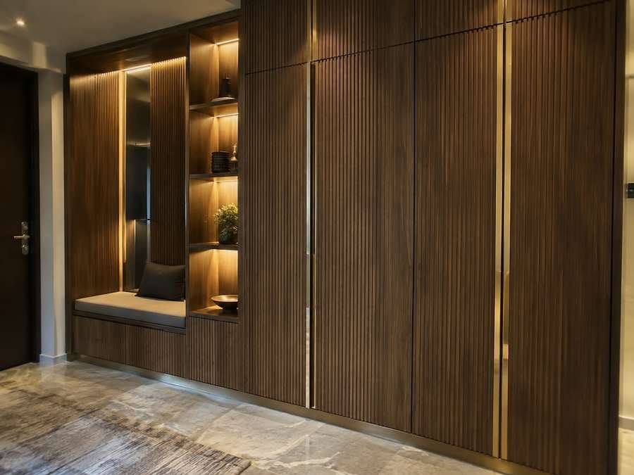 Premium custom dressing room with stone island, glass-front wardrobes and warm lighting