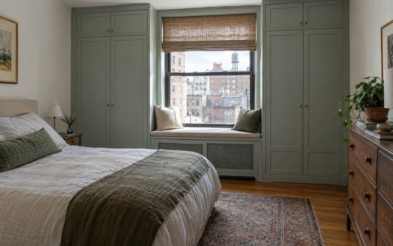 A small New York bedroom with a built-in wardrobe wall wrapping a window seat, design concept